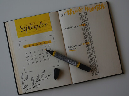 A pristine white planner with a pen neatly resting on top