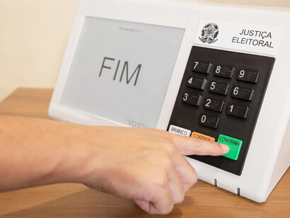 A close-up of a voter pressing the confirm button to cast their ballot in Brazil’s presidential elections
