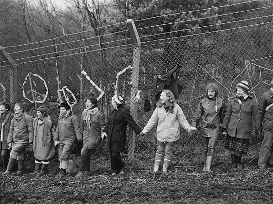 © Edward Barber 
‘Embrace the Base’: 30,000 women link hands, completely surrounding the nine mile perimeter fence at RAF/USAF Greenham Common, Berkshire (1982)

