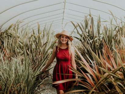 Joven pasea felizmente por un jardín, en una salida consigo misma. Debemos darnos tiempo para hacer lo que deseamos