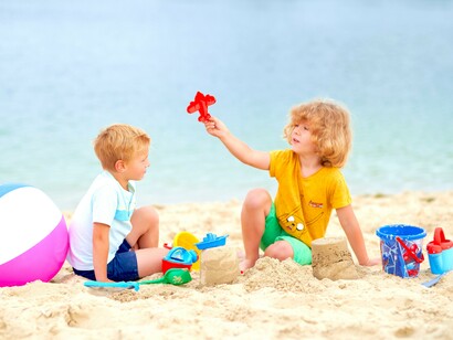 Meninos brincam juntos na areia da praia