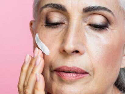 An older women applying anti aging cream with soft hands where beauty takes a high place on today’s society 