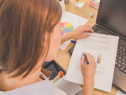 Experience the intersection of fashion trends and consumer insights as a woman examines diagrams on her desktop, showcasing the significance of data visualization in unlocking valuable market research findings while prioritizing data privacy