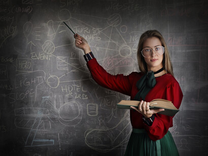 Mujer explica cálculos matemáticos anotados en un pizarrón