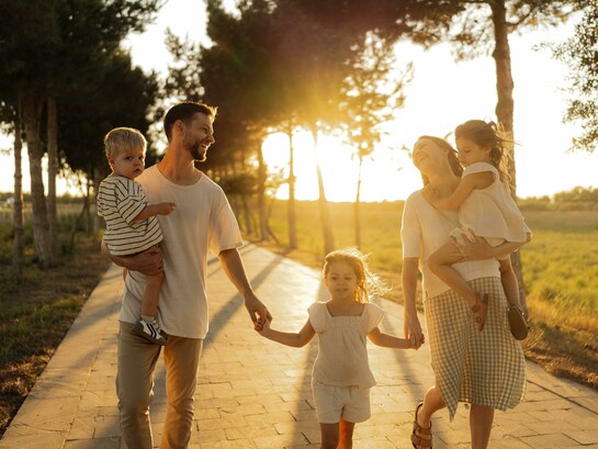 Bathed in the warm glow of sunset, a family enjoys a leisurely walk together, celebrating connection and togetherness