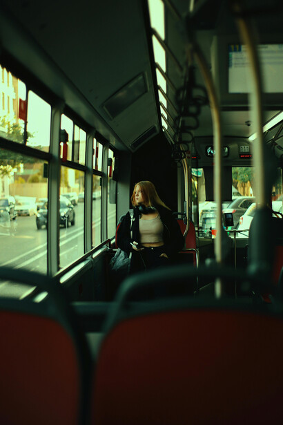 A blonde commuter sits alone on the bus