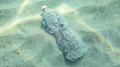 Botella de plástico en el fondo del mar