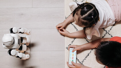 Crianças brincam de programar funções de um robô