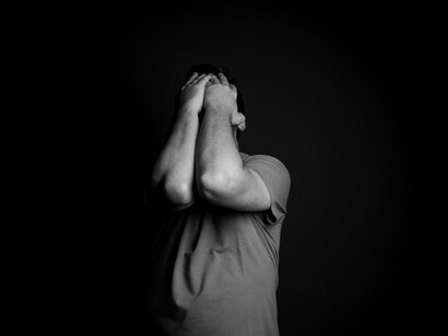 O homem volta a esconder o rosto entre as duas mãos, em uma imagem marcada pelo contraste entre a figura iluminada e o fundo escuro. A composição dialoga com a reflexão do autor sobre as tristezas que permanecem, mas também prepara a passagem para a ideia de que é preciso procurar as coisas boas e deixar as amarguras na gaveta do esquecimento