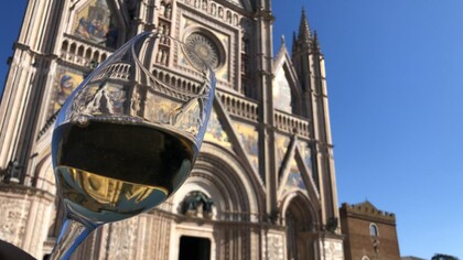 Un bicchiere di Orvieto DOC, sullo sfondo la facciata del Duomo di Orvieto, Italia. Foto di Isabella Ceccarelli