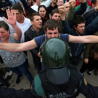 Un manifestante se encara con un policía en Barceloan