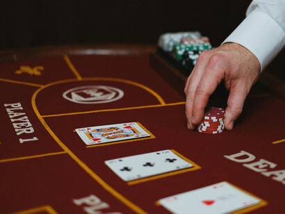 Crupier en una mesa de póker, señalando la apuesta