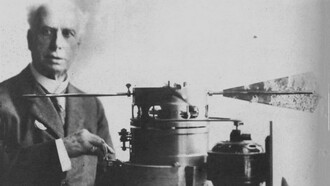 Foto di Lamont Young accanto a un progetto di motore a pale orientabili, 1917