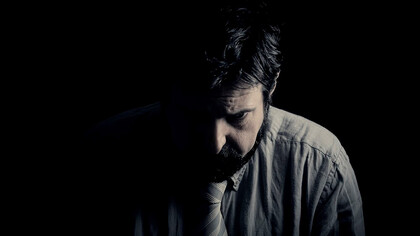 In the depths of darkness, a sorrowful man battles complex emotions, confronting depression and tough choices