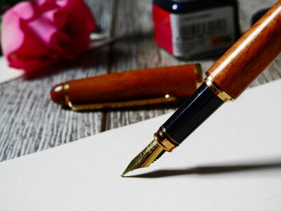 Una pluma escribiendo sobre un papel