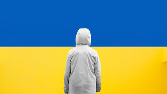 A child standing in front of a blue and yellow wall, Ukrainian flag colors