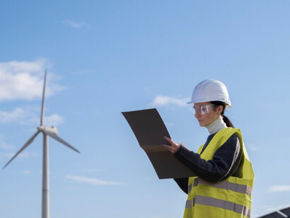 An energy technician reviews project plans at a wind farm highlighting China’s support for digital infrastructure 