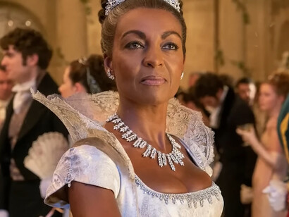 Lady Agatha from Bridgerton wearing a lavish white gown with dramatic lace details and sparkling jewelry, representing the theatrical side of romantic fashion