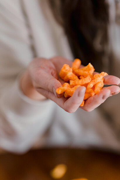A woman holding a bag of crisps—highlighting the appeal and prevalence of processed foods
