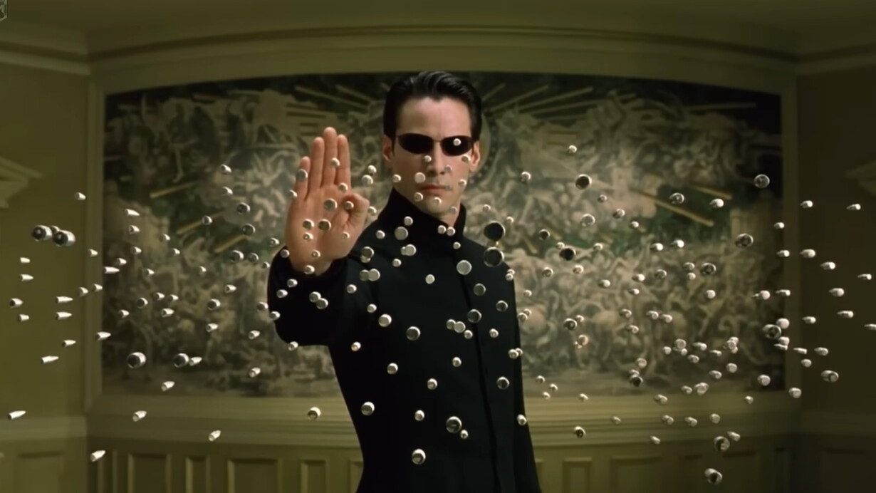 Neo suspending hundreds of bullets in midair with a raised hand, representing one of The Matrix Reloaded's defining moments as he surpasses the limits of the simulated world