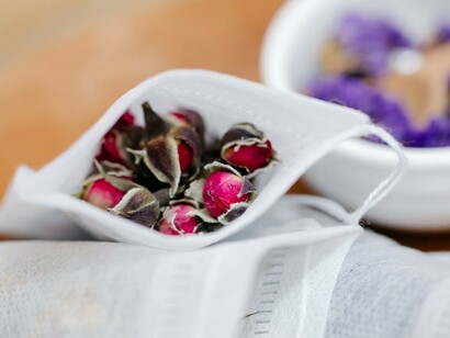 A person packing dried Ayurvedic herbs into bags, highlighting the role of Ayurveda, genomics, personalized medicine, and Prakriti in holistic health practices