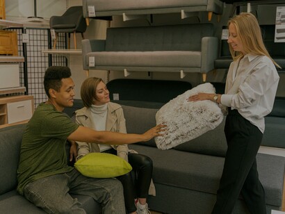 Vendedora mostra almofadas a clientes na loja