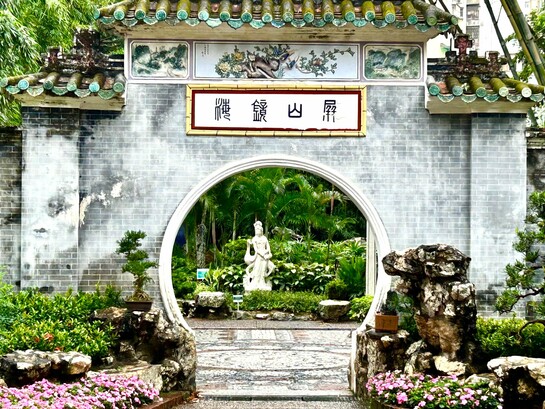 Lou Lim Ioc Garden entrance with a moon-shaped arch and pink blossoms © Alma Reyes