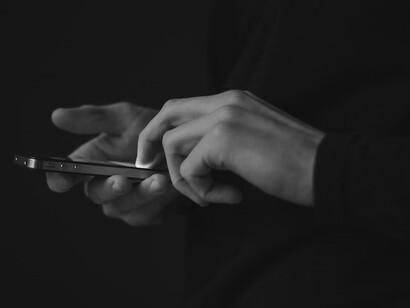 Silhouette photo of person holding smartphone
