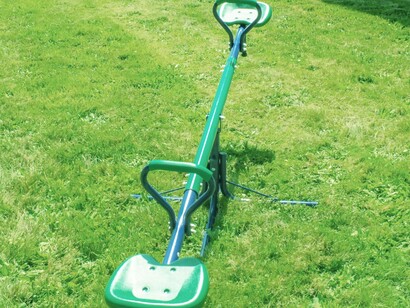 A children's seesaw in the middle of a grassy field hoping to bring joy and motion