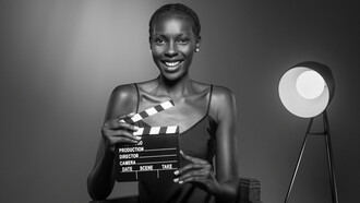The essence of old Hollywood with a striking image of a black woman holding a clapperboard, embodying the role of a producer with timeless elegance and sophistication