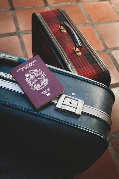 Mérida, Venezuela, a Venezuelan passport lies on a locked leather suitcase, reflecting restricted mobility