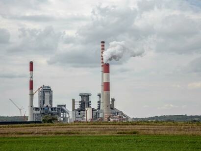 Smoke billows from a fossil fuel power plant highlighting greenhouse emissions 