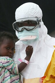 A doctor takes a child in his arms in Liberia