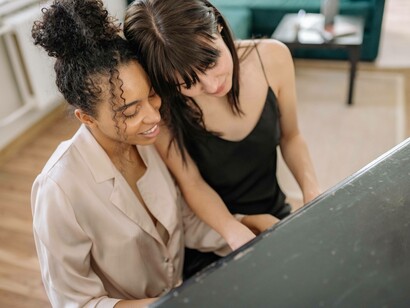 Two women playing the piano together