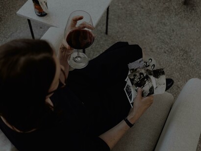 Vista superior de uma mulher segurando fotos e vinho