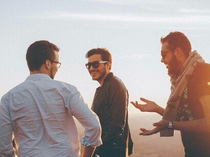 Persone che ridono e parlano tra loro al tramonto