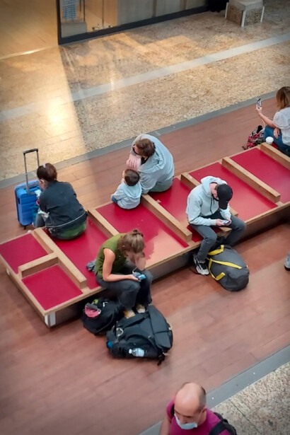 Jeunes gens dans une salle d'attente. Tous sont arcboutés sur leur smartphone, le nez presque suspendu au-dessus des genoux dans la posture de la tortue