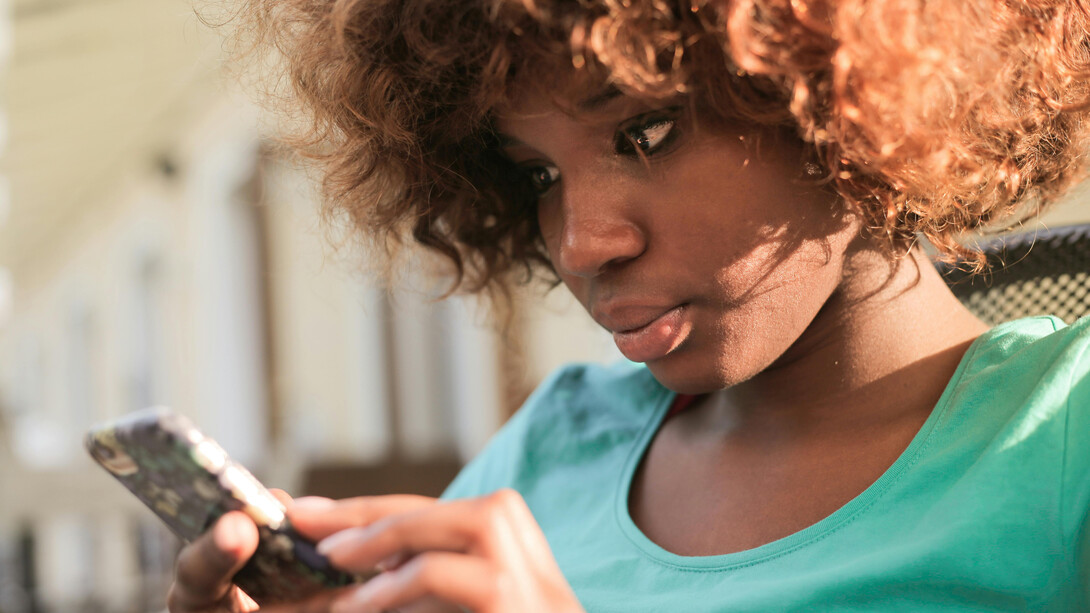 Mulher é influenciada a comprar produtos pelo celular através de anúncio relacionado aos seus gostos pessoais guardados na interação com outras redes sociais