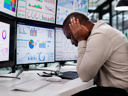 Surrounded by charts, notifications, and analytics, an exhausted office worker experiences the cognitive burden of constant digital engagement