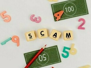 Colorful letter blocks spelling “scam” scattered across a desk, representing the deceptive tactics used in social engineering attacks