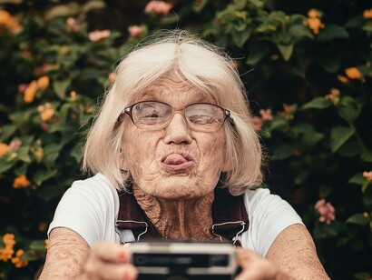 An elderly woman sticking her tongue out at the challenges she's facing at this current stage in life