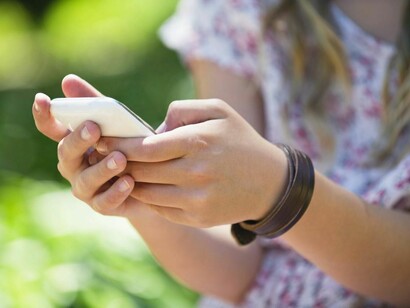 Una chica chateando con su teléfono móvil