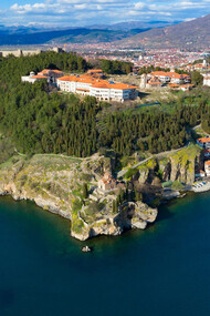 Scenic aerial view of Ohrid, North Macedonia, nestled amidst mountains and overlooking Lake Ohrid on a bright sunny day