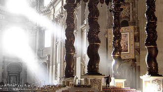 The ancient Solomonic columns mounted above the balcony, positioned in the upper-right background against the wall in St. Peter's Basilica, Vatican City, Italy