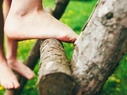 Piedi nudi su un tronco: "Prima dell’invenzione delle scarpe moderne con suole ammortizzate, l’umanità ha camminato e corso a piedi nudi per milioni di anni"