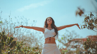 In the serene morning light, a yogini finds balance amidst ancient ruins, blending tradition with contemporary wellness practices