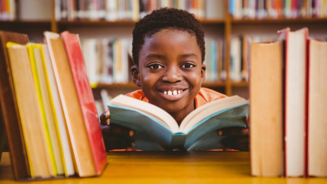 Niño disfrutando la lectura en una biblioteca