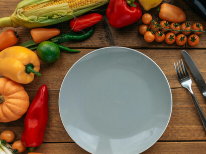 A plate surrounded by colorful vegetables embodies the Ayurvedic principle of eating with the seasons 