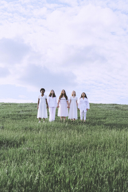 Women stand together in harmony in nature