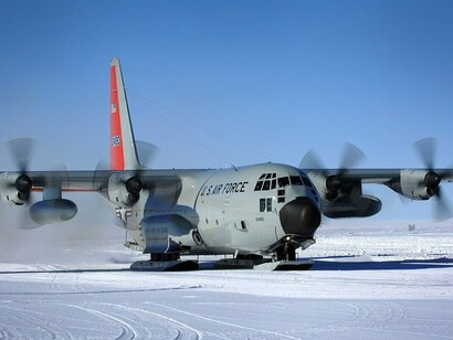 Um LC-130 Hercules equipado com esquis pousa em um remoto posto de pesquisa na camada de gelo da Groenlândia. A capacidade de operar sobre o gelo tornou esse tipo de aeronave essencial para as atividades científicas e logísticas em regiões polares